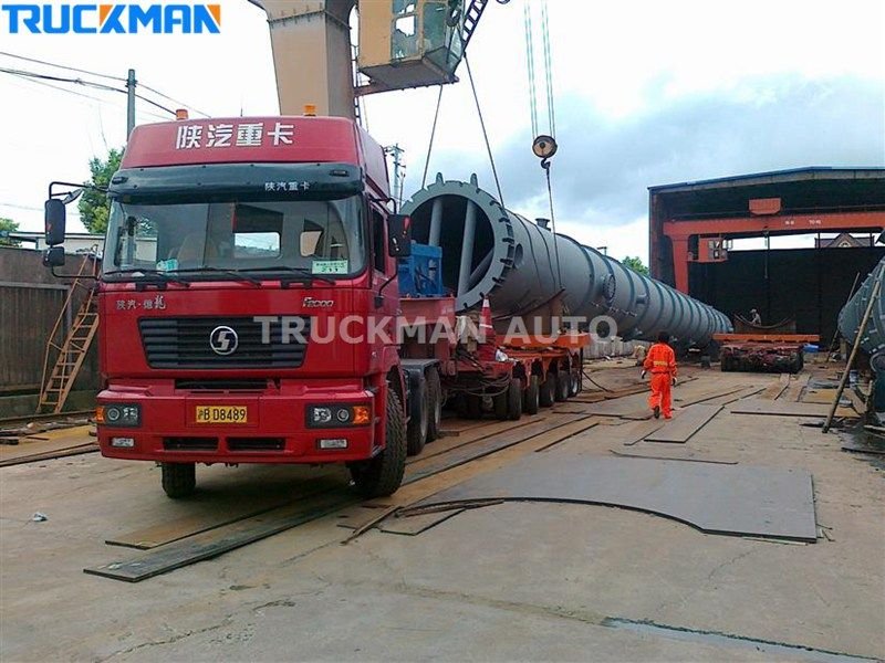 Semirremolque de plataforma baja que transporta una cargadora de ruedas y un bulldozer amarillos
