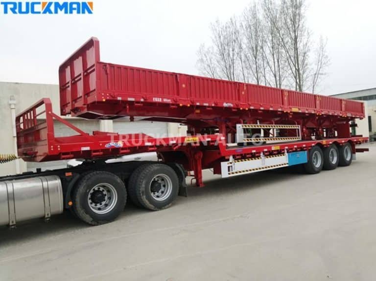 Semirremolque rojo de plataforma baja estacionado y listo para la carga de mercancías