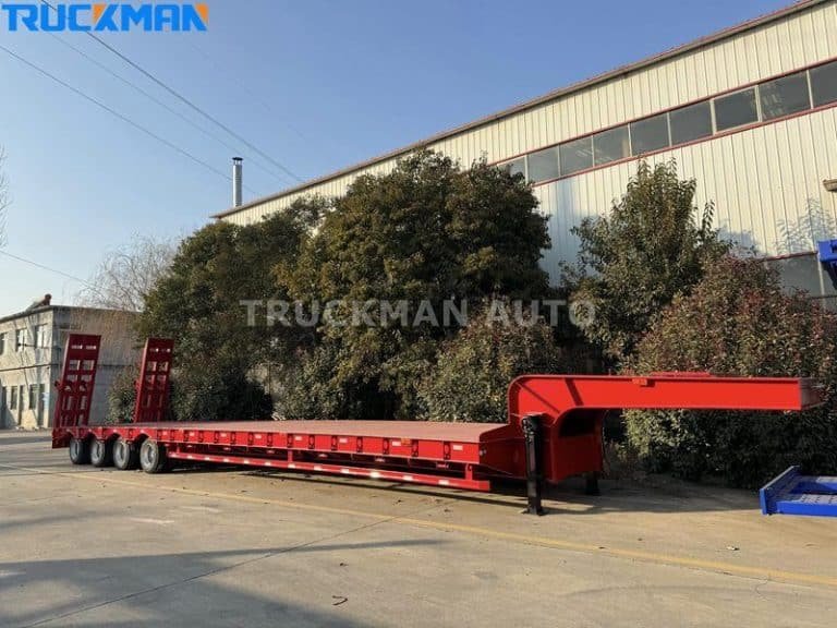 Semirremolque rojo de plataforma baja fuera del taller, listo para una revisión profesional de mantenimiento y servicio