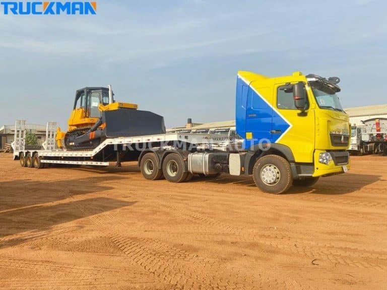 Maquinaria de construcción preparada para su transporte en un semirremolque de plataforma baja