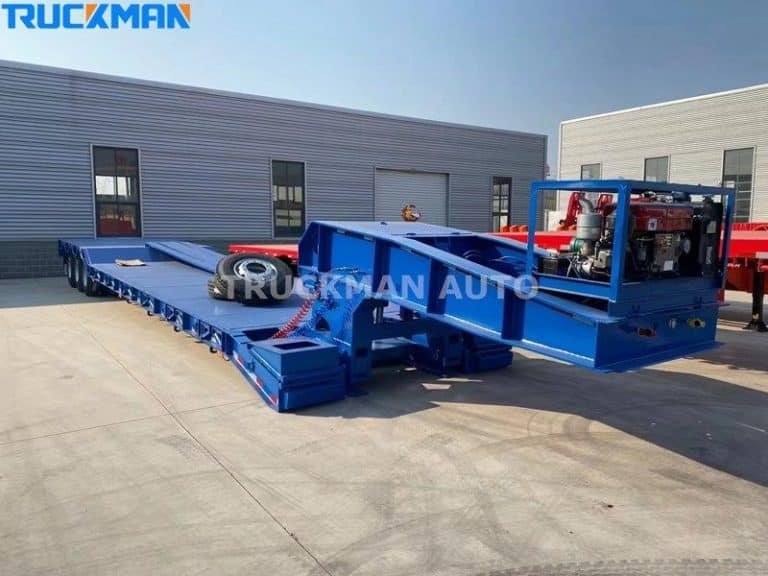 Semirremolque azul de plataforma baja mostrando su espaciosa plataforma de carga y su cuidado estado, listo para su uso