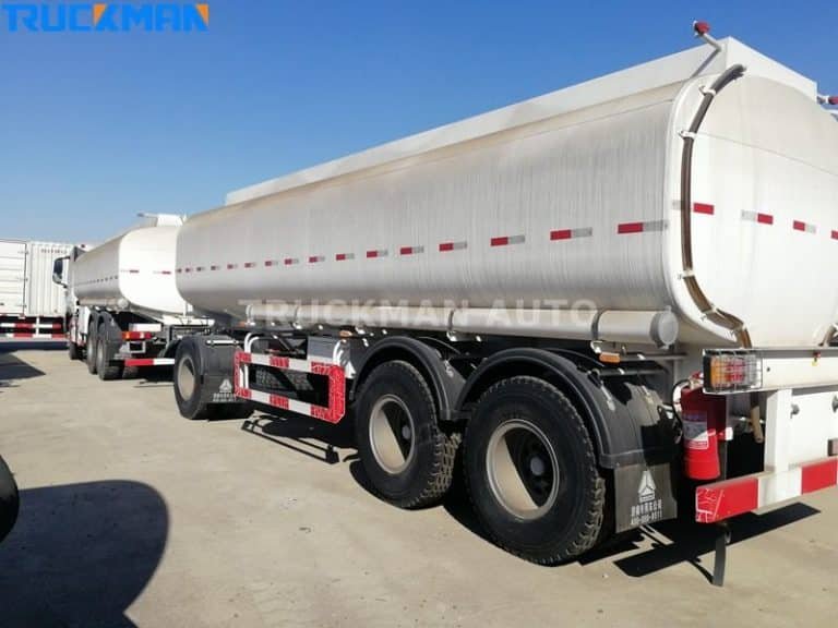 Vista trasera de un remolque cisterna plateado para productos químicos con válvulas de seguridad, afiliado a Truckman Auto