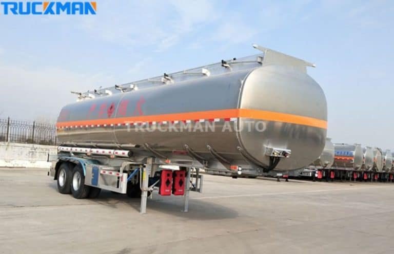 Vista lateral de un remolque cisterna para combustible de aleación de aluminio TRUCKMAN AUTO con múltiples etiquetas de seguridad y patas de apoyo reforzadas.