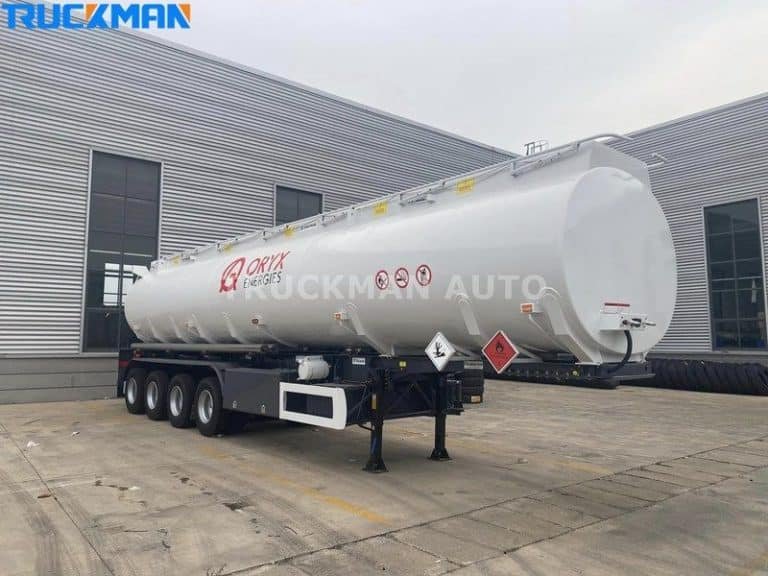 Remolque cisterna blanco marcado con la señal de materiales peligrosos fuera del almacén