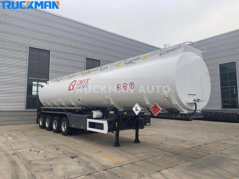 Camión cisterna de combustible blanco listo para el transporte de mercancías peligrosas con señales de advertencia de seguridad