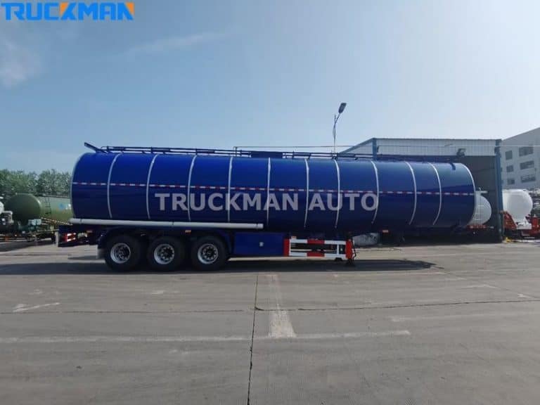 Vista lateral de un remolque petrolero azul de Truckman Auto, equipado para el transporte de materiales peligrosos