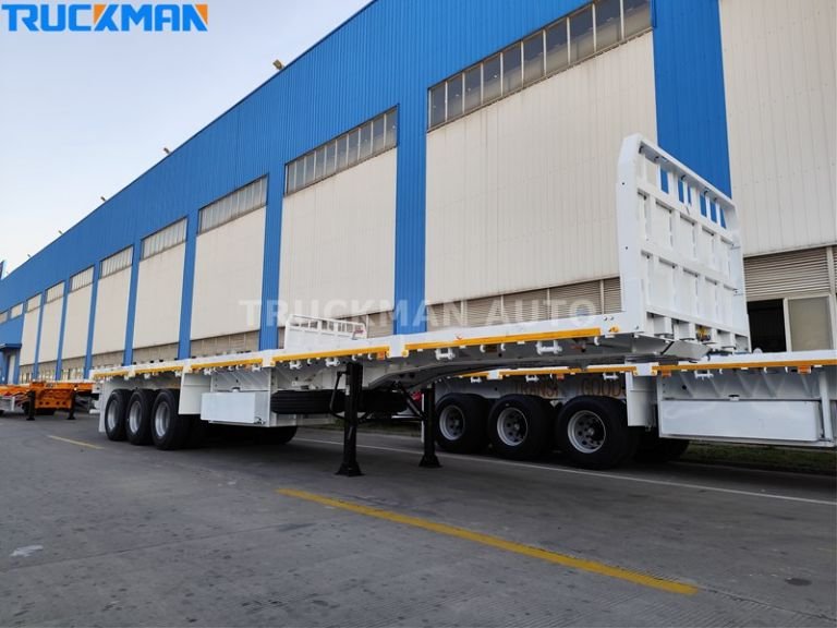 Camionero semirremolque de plataforma plana estacionado fuera de una planta de fabricación