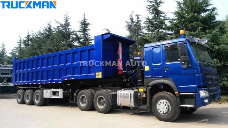 Semirremolque azul de carga pesada y descarga trasera, diseñado para el transporte de grandes cantidades de materiales a granel en obras de construcción